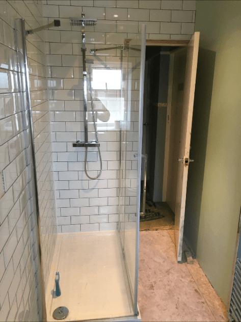 Finished walk-in shower with glass screen and white metro tiling